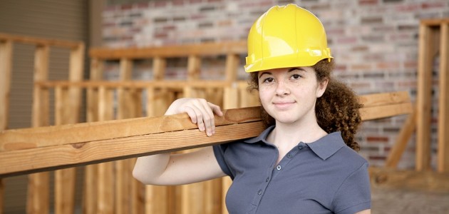 jeune fille qui porte des planches de bois